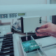 Фотосъёмка производственного процесса пайки микросхемы на печатную плату в лаборатории оптико-механического предприятия БелОМО ЛЕМТ LEMT