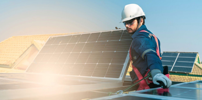 Пример фотосъёмки предприятия из области альтернативной энергетики, монтажник держит в руках панель солнечной батареи