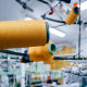 Фотография катушек с оранжевыми нитками на ткацком станке на фабрике по производству медицинских бинтов и бандажей в городе Молодечно, Беларусь