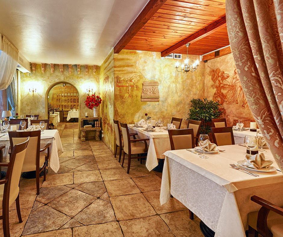 Интерьерная съёмка итальянского ресторана. Интерьер большого обеденного зала с видом на малый зал.