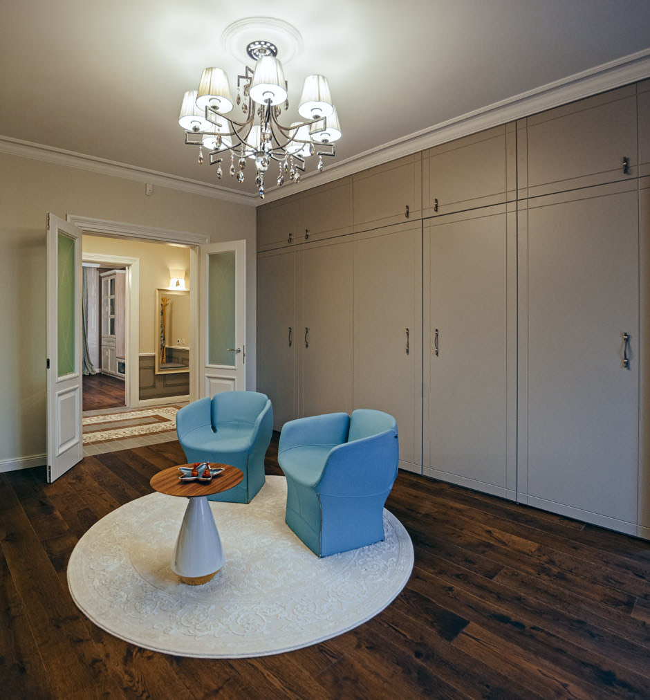 Интерьер зала в квартире стиля эклектика, вид на дизайнерские кресла, встроенный шкаф и гостинную комнату