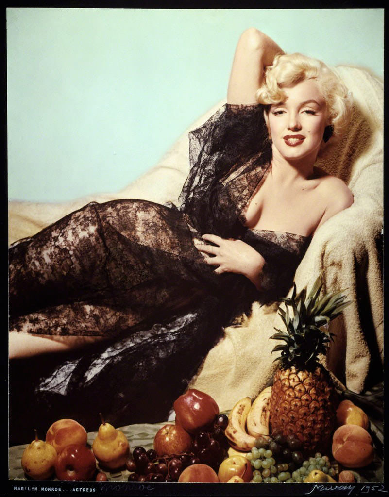 Фото портрет американской актрисы Мэрилин Монро на диване с натюрмортом из свежих фруктов