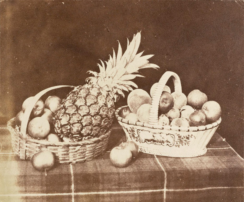 Фотография еды, натюрморт из персиков и ананаса в корзинах на столе