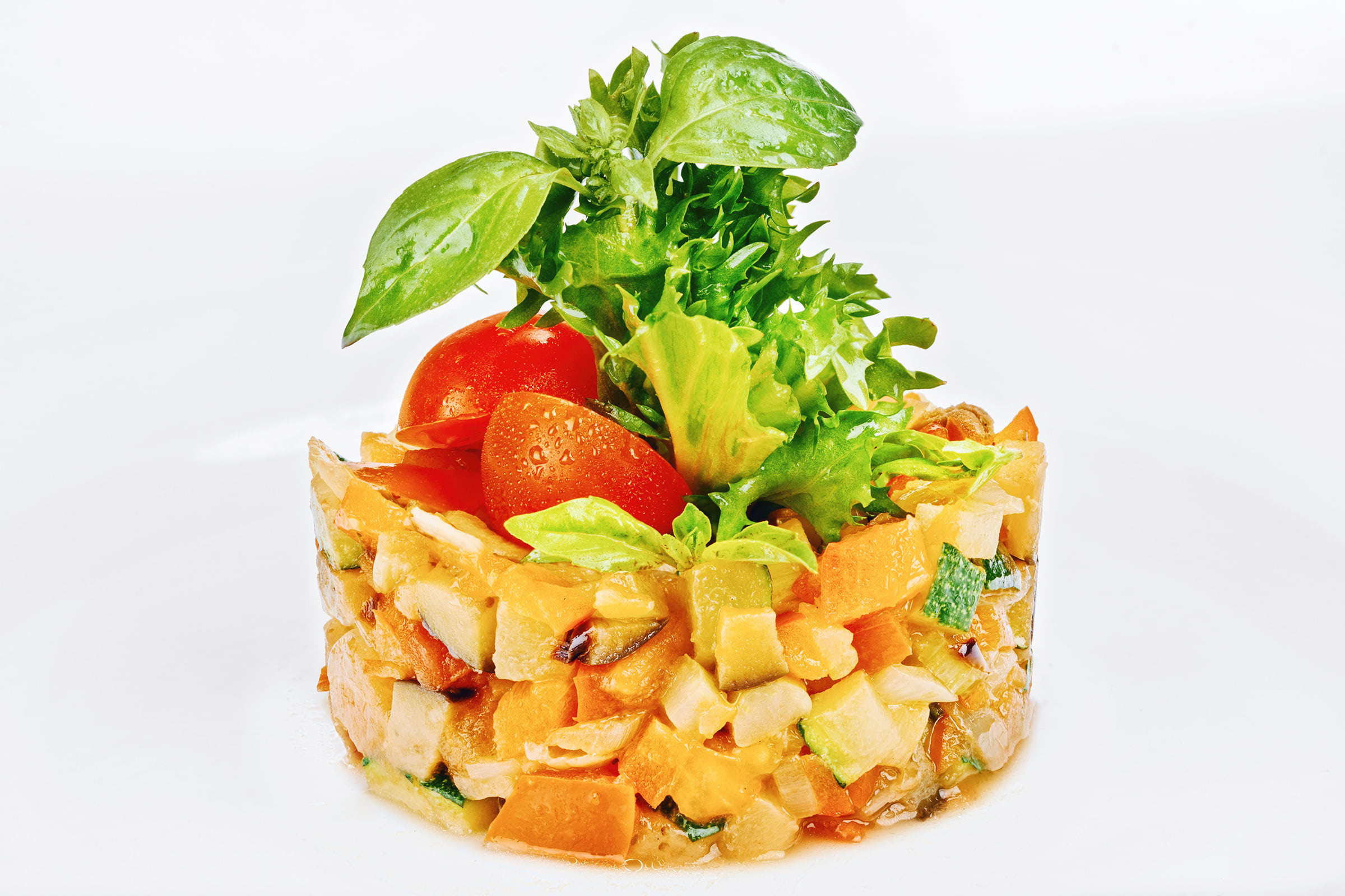 Съёмка ресторанных блюд и напитков для печатного меню или сайта; фото закусочного блюда салат из кусочков свежих овощей украшен листьями свежей рукколы и томатами