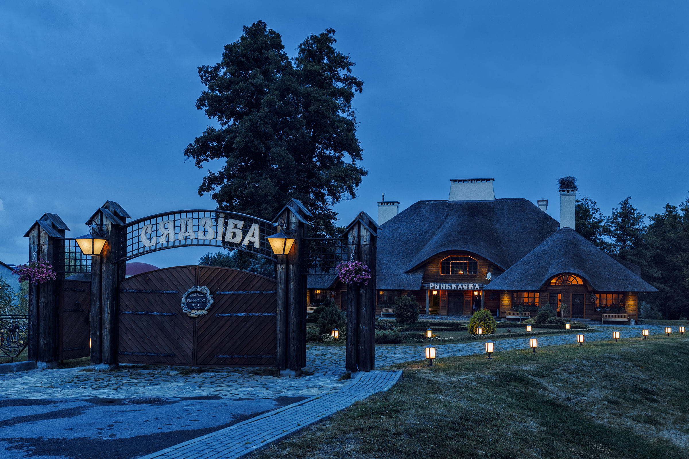 Архитектурная съёмка объектов индустрии туризма и гостеприимства - экстерьерное фото аграрной усадьбы с ресторанам и светящимися фонарями в вечернее время