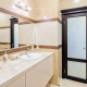 Интерьерная фотография ванной комнаты с большим зеркалом на стене в тёплых оттенках, услуги фотографа в Минске
