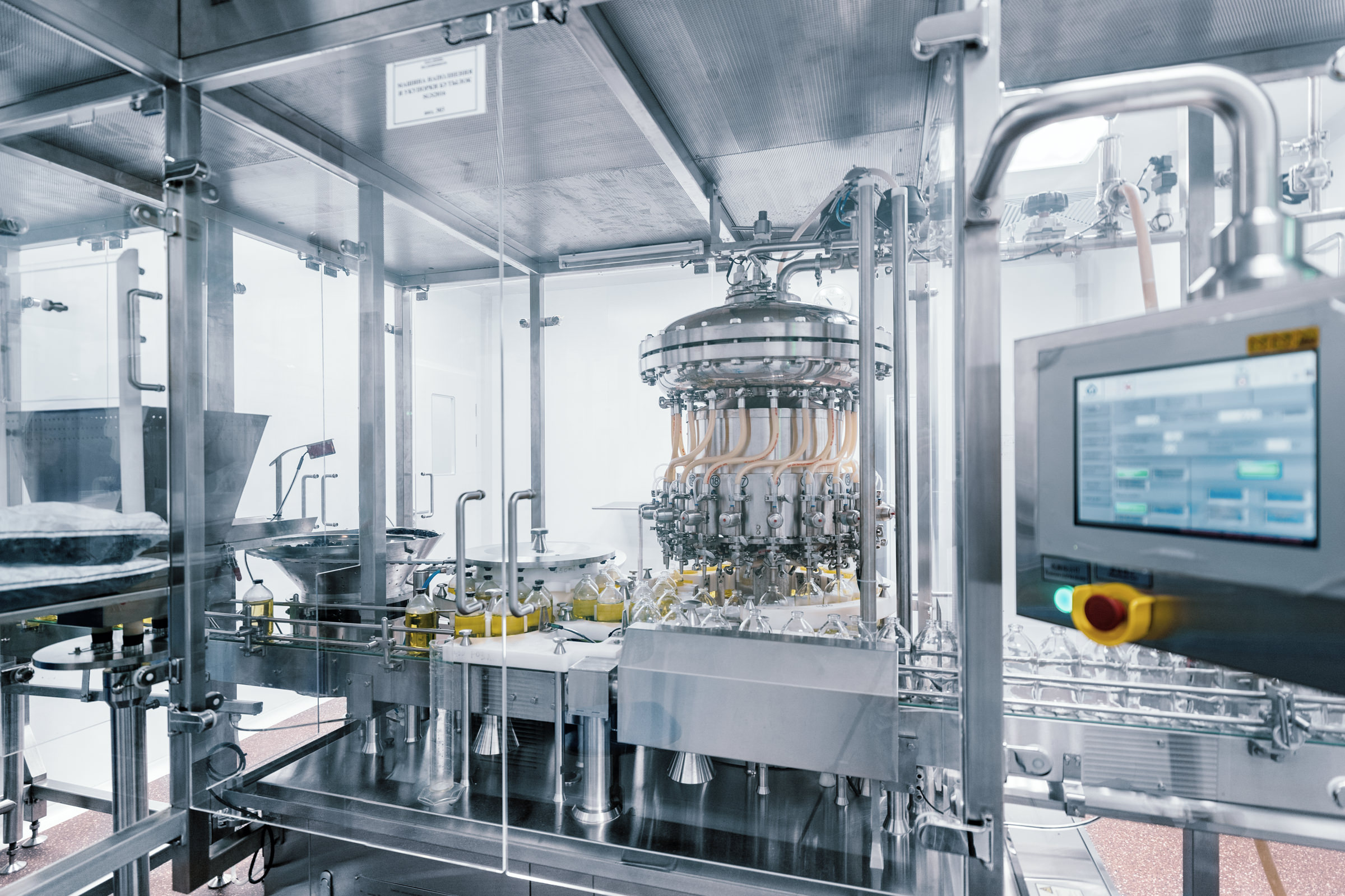 Производственная линия по розливу жидких медицинских препаратов, фотография современного промышленного оборудования с компьютерным управлением