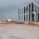 Фотосъемка строительства гостинично-развлекательного комплекса в центре Минска, вид на город с крыши здания, укрытой изоляционным материалом и металлической арматурой