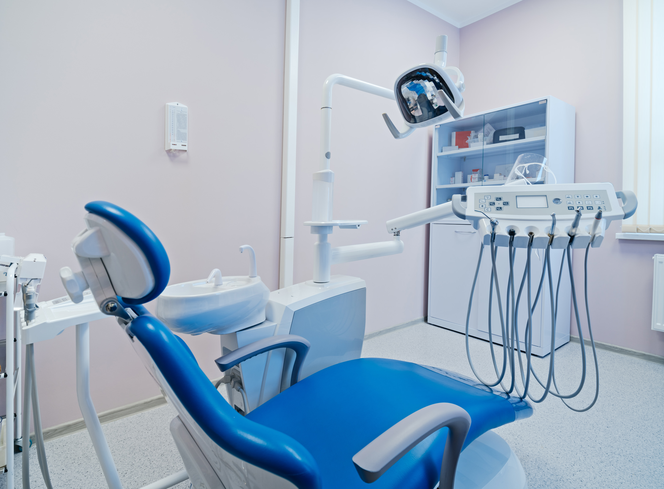 Профессиональная интерьерная съёмка стоматологического кабинета в поликлинике Минска, кресло пациента с бур-машиной и лекарствами в шкафу