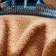 Макро фотография элемента ткацкого станка с иголками, нитками и готовым полотном для производства медицинских компрессионных чулков